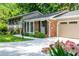 Charming home featuring a brick facade, well-manicured lawn, and beautiful landscaping at 6505 Whispering Ln, Atlanta, GA 30328