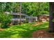 Two story traditional home featuring a well manicured lawn and mature landscaping at 6505 Whispering Ln, Atlanta, GA 30328