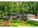 Traditional home showcasing lush green lawn, mature trees, and well-kept landscaping at 6505 Whispering Ln, Atlanta, GA 30328