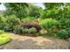 Backyard garden featuring lush foliage and a gate leading to a walkway at 2324 Littlebrooke Ln, Dunwoody, GA 30338