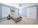 Comfortable bedroom with blue walls, plantation shutters, ceiling fan, and double door closet at 2324 Littlebrooke Ln, Dunwoody, GA 30338