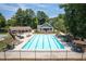 Community pool with chairs and umbrellas surrounded by trees at 2324 Littlebrooke Ln, Dunwoody, GA 30338