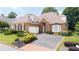 Charming brick home featuring manicured landscaping, a two-car garage, and a well-maintained front yard at 2324 Littlebrooke Ln, Dunwoody, GA 30338