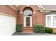 Inviting front entrance showcasing brickwork, an arched window, and decorative exterior lighting fixtures at 2324 Littlebrooke Ln, Dunwoody, GA 30338