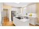 Stylish kitchen featuring stainless appliances, white cabinetry, a center island, and hardwood floors at 2324 Littlebrooke Ln, Dunwoody, GA 30338