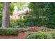 Beautiful landscaping featuring a brick wall, trimmed hedges, and colorful flowers at 2324 Littlebrooke Ln, Dunwoody, GA 30338