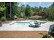 Inviting pool area with ample seating, umbrellas, and tables, surrounded by well-maintained landscaping at 2324 Littlebrooke Ln, Dunwoody, GA 30338