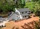 Aerial view of the property showing the house, deck, driveway, and the surrounding trees at 1143 Mcgarity Rd, Mcdonough, GA 30252