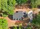 Aerial view of the house showing the roofline, driveway, and the surrounding wooded lot at 1143 Mcgarity Rd, Mcdonough, GA 30252