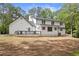 Rear exterior of the house showing the deck, white brick and siding, and the surrounding trees at 1143 Mcgarity Rd, Mcdonough, GA 30252