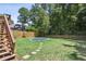 Fenced backyard with a trampoline surrounded by lush green grass and mature trees, ideal for outdoor fun at 2567 Briers North Dr, Dunwoody, GA 30360