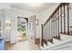 Bright, airy foyer with hardwood floors, white wainscoting, and a staircase with black wrought iron railing at 2567 Briers North Dr, Dunwoody, GA 30360