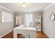 Home office with a white L-shaped desk, ample shelving for storage, and large windows for natural light at 2567 Briers North Dr, Dunwoody, GA 30360