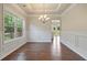 Dining room featuring hardwood floors, elegant chandelier, and classic wainscoting at 4650 Pleasant Woods Dr, Cumming, GA 30028