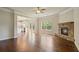 Open-concept living room with hardwood floors, a fireplace, and access to a bright kitchen and outdoor space at 4650 Pleasant Woods Dr, Cumming, GA 30028