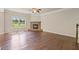 Inviting living room with hardwood floors, a corner fireplace, and a large window offering scenic views at 4650 Pleasant Woods Dr, Cumming, GA 30028