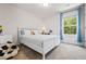 Bright bedroom with large window with blue curtains, neutral walls, and white furniture at 118 Woodhouse Cir, Acworth, GA 30102