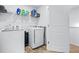 Well-lit laundry room featuring modern washer and dryer units, with overhead storage shelves at 118 Woodhouse Cir, Acworth, GA 30102