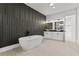 Contemporary bathroom with a freestanding tub, dual vanities, and stylish accent wall at 1604 Greendale Rd, Covington, GA 30014