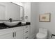Stylish powder room featuring modern fixtures and a vanity with a black countertop at 1604 Greendale Rd, Covington, GA 30014