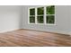 Bright bedroom featuring three large windows and beautiful wood-look flooring at 1604 Greendale Rd, Covington, GA 30014