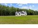 Modern farmhouse sitting on large lot surrounded by a picturesque lawn and mature trees at 1604 Greendale Rd, Covington, GA 30014