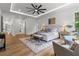 Sunlit main bedroom with a sitting area, wood floors, and neutral decor at 1604 Greendale Rd, Covington, GA 30014