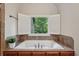 Close up of a jacuzzi-style tub featuring tiled accents and plantation shutters at 1917 Oak Grove Ne Rd, Atlanta, GA 30345