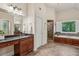 Large bathroom with tiled floors, a walk-in shower, and a soaking tub under a bright window at 1917 Oak Grove Ne Rd, Atlanta, GA 30345
