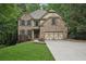 Beautiful brick home featuring a two-car garage, manicured lawn, and mature trees at 1917 Oak Grove Ne Rd, Atlanta, GA 30345