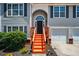 Close-up of front entrance with orange stairs and garage at 4426 High Gate Nw Dr, Acworth, GA 30101