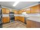 Efficient kitchen featuring stainless steel appliances, wood cabinets, and tile backsplash for easy cleaning at 4426 High Gate Nw Dr, Acworth, GA 30101