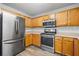 Well-lit kitchen boasts stainless steel appliances, including a refrigerator, oven, and microwave for modern convenience at 4426 High Gate Nw Dr, Acworth, GA 30101