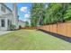 Large backyard featuring a stained fence and beautiful lawn at 450 Hilingdon Way, Suwanee, GA 30024