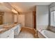 Bathroom featuring granite countertops, dual sinks, a soaking tub and glass-enclosed shower at 450 Hilingdon Way, Suwanee, GA 30024