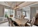 Dining room features a modern chandelier, large windows, and neutral gray walls at 450 Hilingdon Way, Suwanee, GA 30024