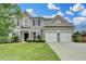 Charming brick two-story home with well-manicured lawn and attached two-car garage at 450 Hilingdon Way, Suwanee, GA 30024
