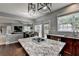 Kitchen island with granite top, stainless steel appliances, and open dining area at 450 Hilingdon Way, Suwanee, GA 30024