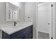 Bathroom featuring a marble countertop, dark blue vanity and a door to a walk in closet at 4847 Royal Dr, Duluth, GA 30096