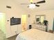 Bedroom featuring a ceiling fan, TV, and mirrored dresser leading to ensuite bathroom at 1012 Chapman Cir, Stone Mountain, GA 30088
