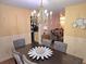 Well-lit dining room with a chandelier, seating for six, decorative wall art, and open access to other rooms at 1012 Chapman Cir, Stone Mountain, GA 30088