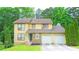 Charming two-story home featuring a two-car garage, stone accents, and a well-manicured front yard at 1012 Chapman Cir, Stone Mountain, GA 30088