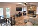 Cozy living room featuring a stone fireplace, ceiling fan, comfortable seating, and access to an outdoor deck at 1012 Chapman Cir, Stone Mountain, GA 30088