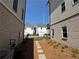 View of newly landscaped backyard with stone paver path and view of neighboring homes at 157 Basil St, Cumming, GA 30040