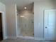 Modern bathroom featuring a glass-enclosed shower with a bench, offering a relaxing retreat at 157 Basil St, Cumming, GA 30040