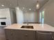 Bright kitchen featuring a large island with a stainless steel sink, quartz countertop, and modern pendant lighting at 157 Basil St, Cumming, GA 30040
