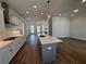 Open-concept kitchen showcasing an island, stainless steel appliances, white cabinetry, and hardwood flooring at 157 Basil St, Cumming, GA 30040