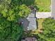 An aerial view showcasing a home's roof, driveway, landscaping, and backyard nestled among lush trees at 4941 Lighthouse Pointe, Acworth, GA 30101