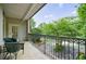 Outdoor balcony with wrought iron railing, patio furniture, and a view of mature trees at 50 Biscayne Dr # 2106, Atlanta, GA 30309