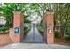 Secured entrance gate to residential complex, featuring brick pillars and lush greenery at 50 Biscayne Dr # 2106, Atlanta, GA 30309